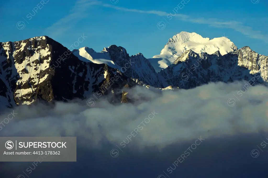 Barre des Ecrins in sunlight view over the fog Alps France
