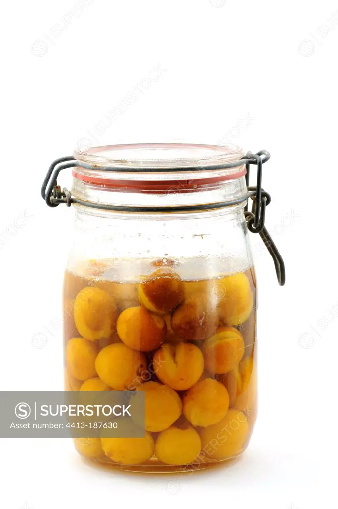 Canning jar of Mirabelles on white background