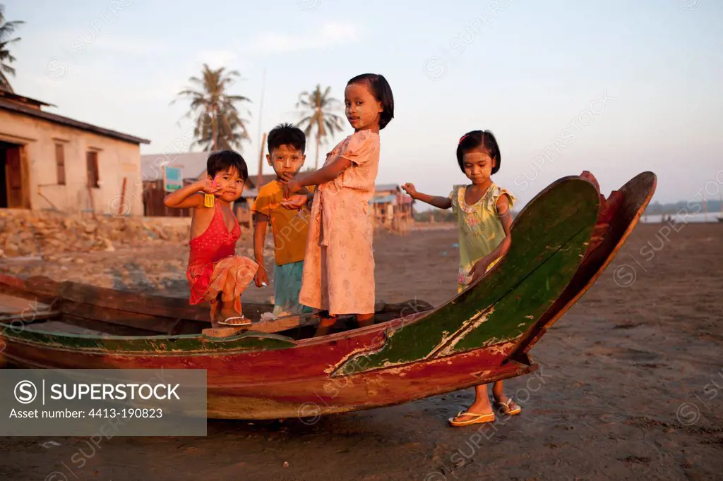 Group of children on a boat at low tide in Burma