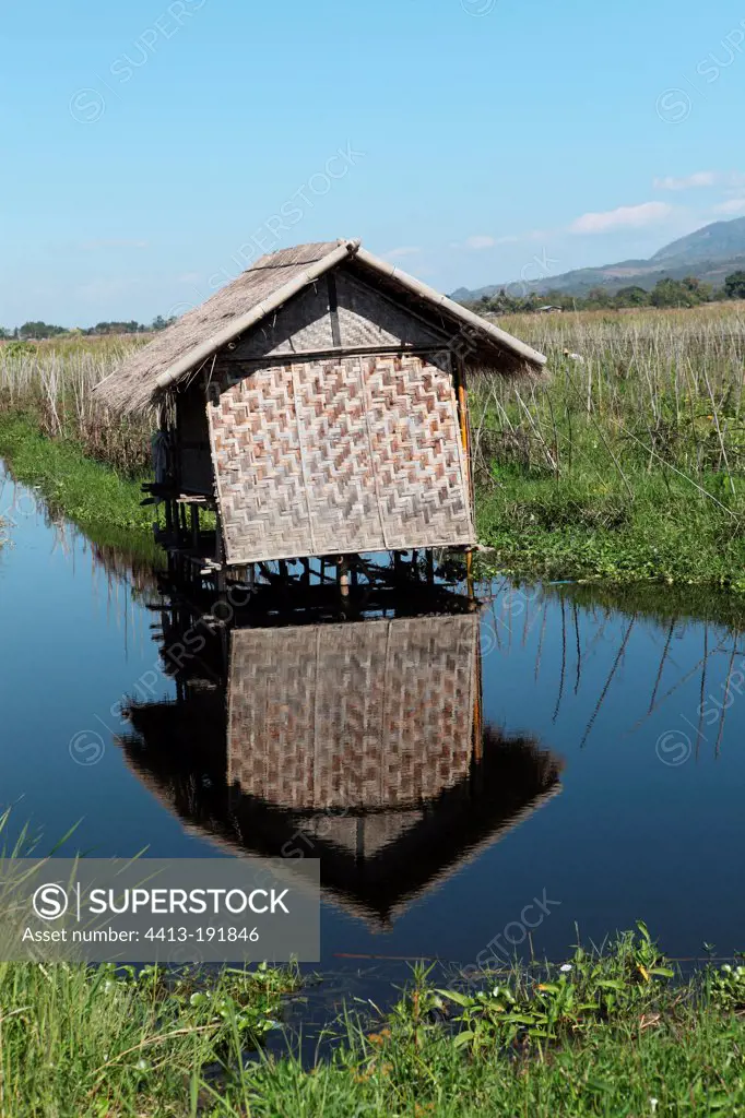 Bamboo hut on stilts and its reflection in Inle LakeBurma