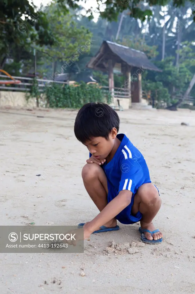 Boy playing with Urchin Archipelago Bacuit El Nido Palawan