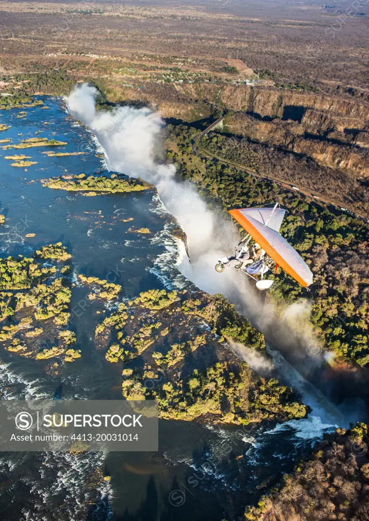 Tourists fly over the Victoria Falls on the trikes. Africa. Zamb