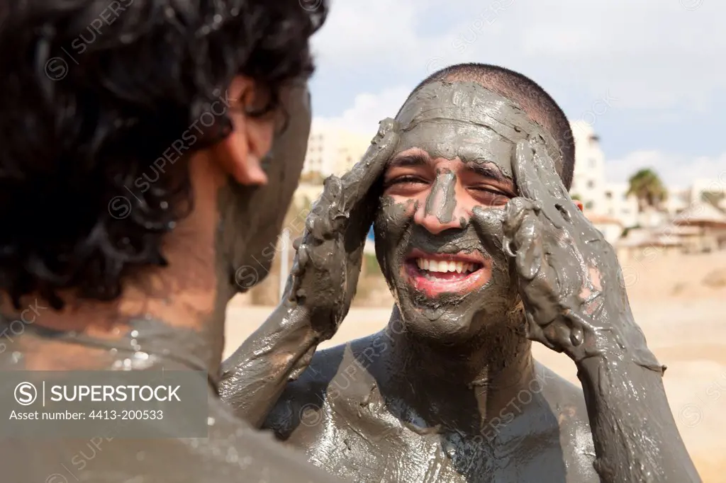 Tourists smearing mud on the banks of the Dead SeaJordan