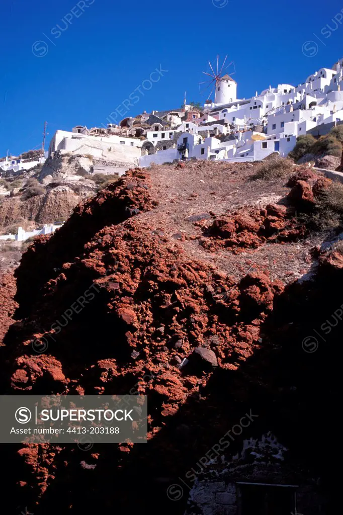 Village overlooking a volcanic rocks cliff Greece