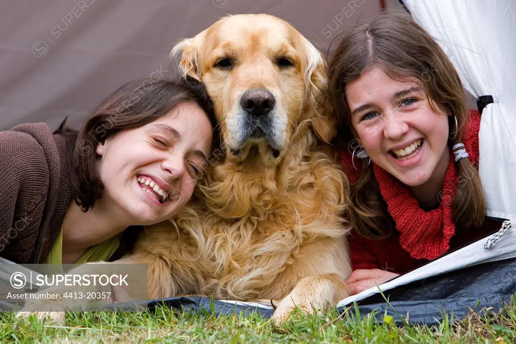 Children under a tent with a dog Golden Retriever France