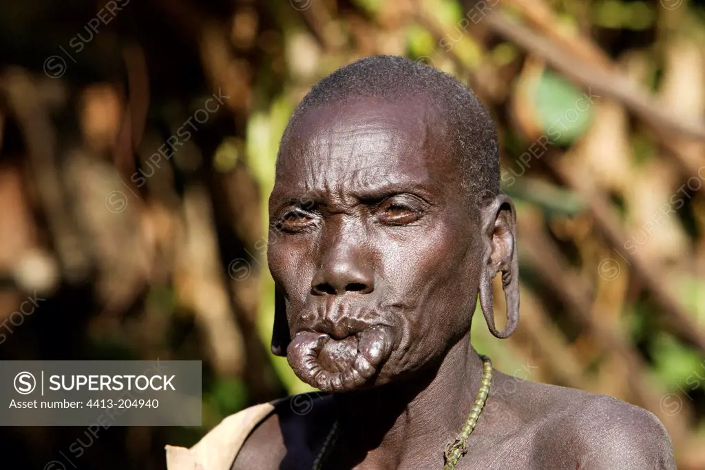 Surma old woman with stretched lip and earlobes