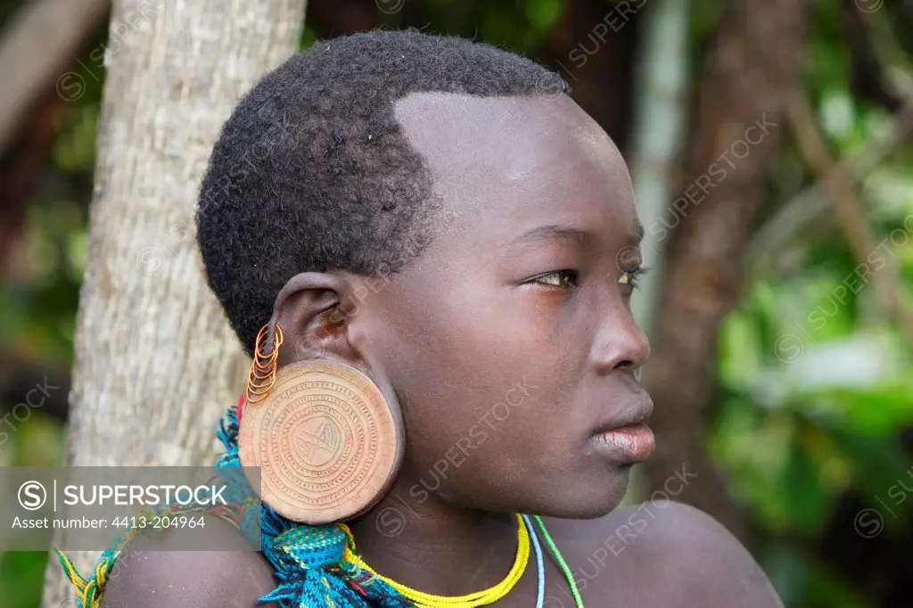 Surma teen girl wearing an ear plate Ethiopia