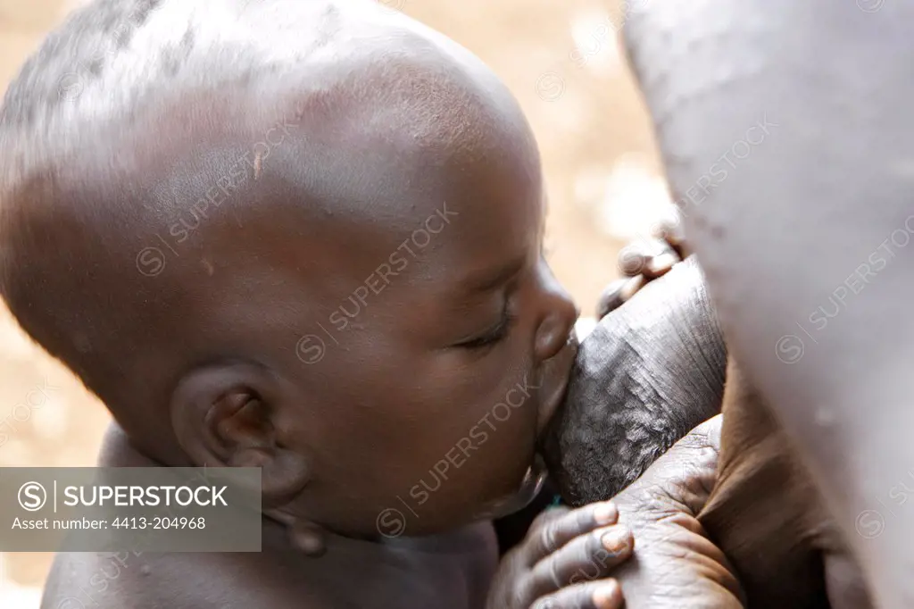 Surma infant sucking at mother's breast Ethiopia
