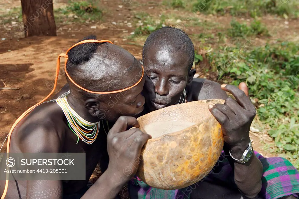 Surma men drinking corn beer in a kalabash Ethiopia