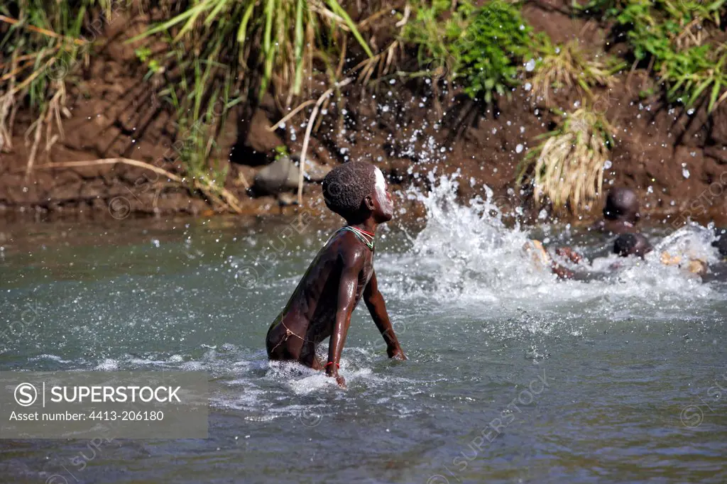 Surma boy playing in the water Ethiopia