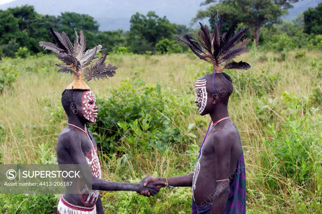 Body-painted Surma boys shaking hands Ethiopia