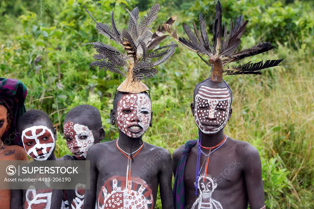 Body-painted Surma children wearing feather headdresses