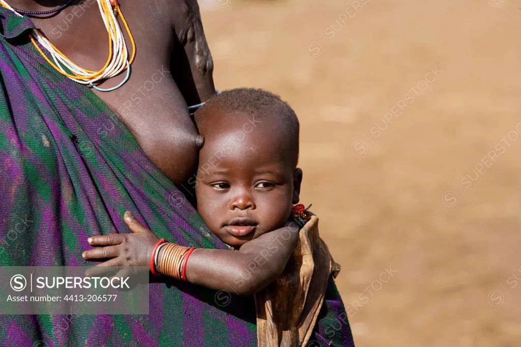 Portrait of a Surma infant in mother's arms Ethiopia