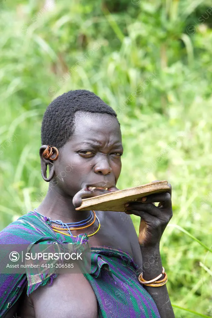 Surma woman placing her lip plate Ethiopia