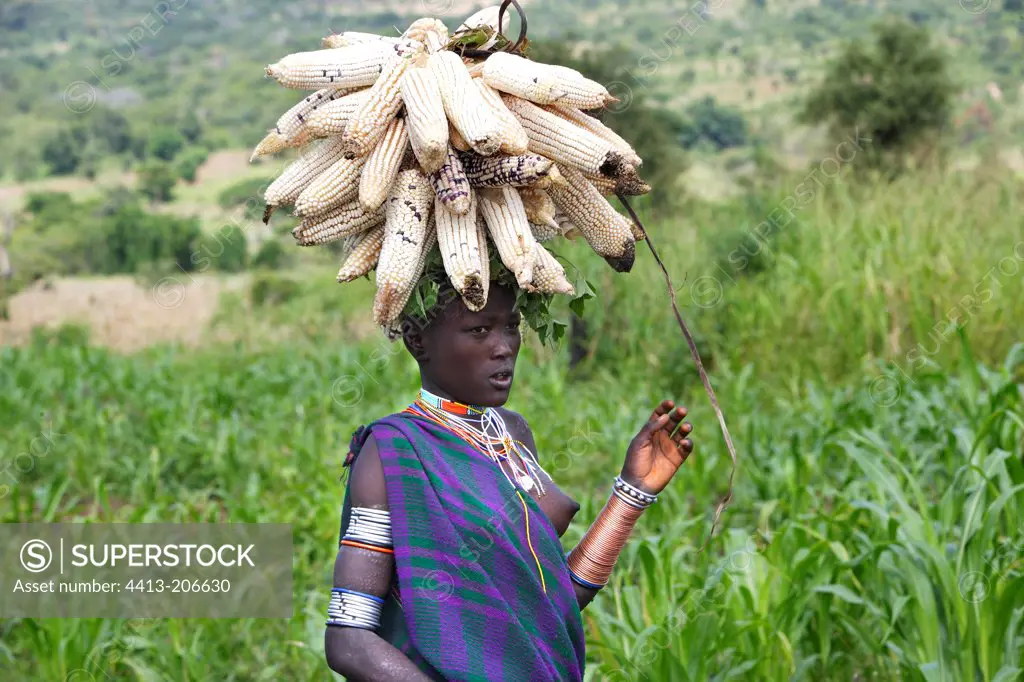 Surma woman carrying corn ears on her head Ethiopia