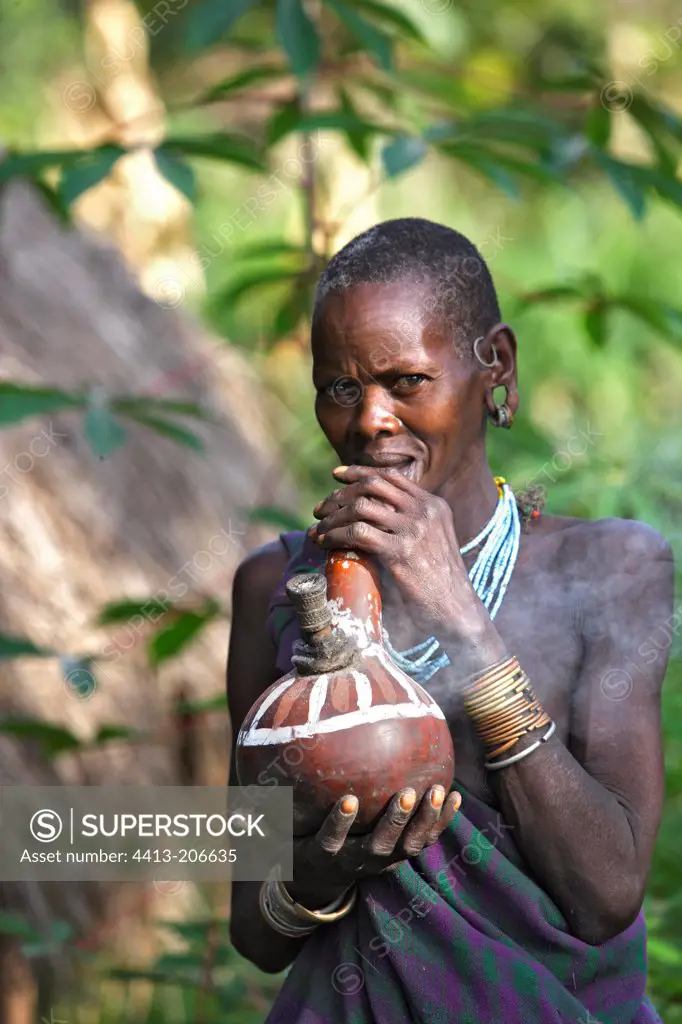 Portrait of a Surma woman smoking with a calabash Ethiopia