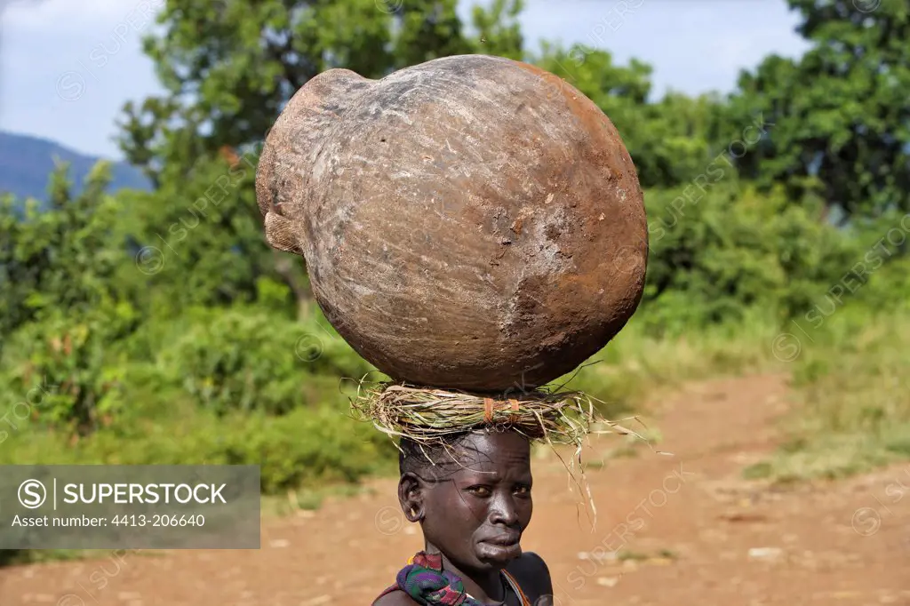 Surma woman carrying a big jar on the head Ethiopia