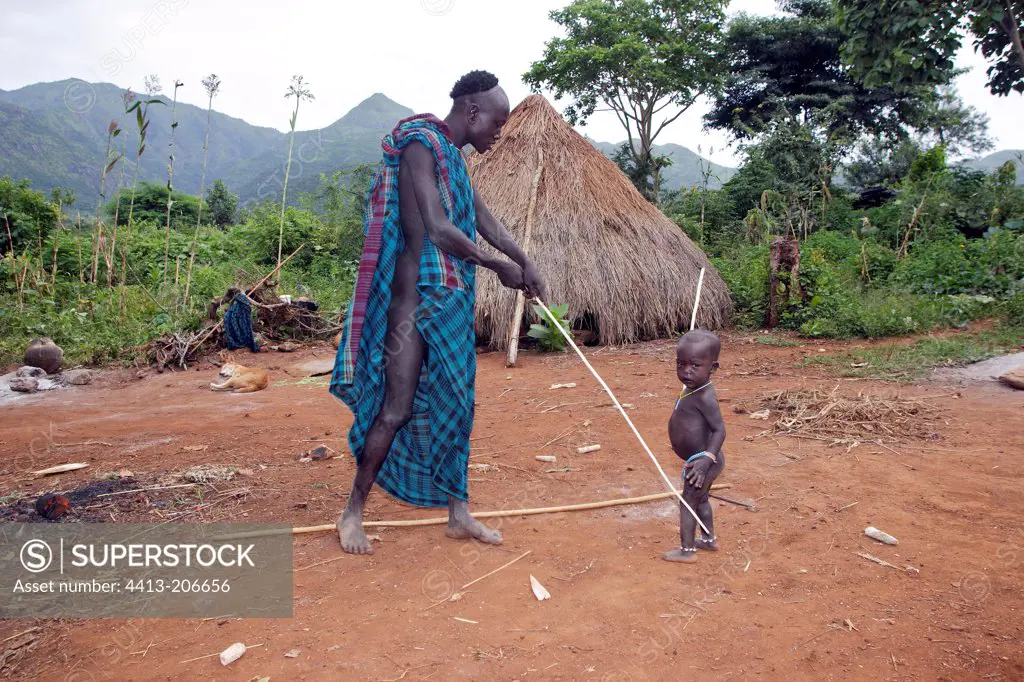 Surma man training his son for stick fighting Ethiopia