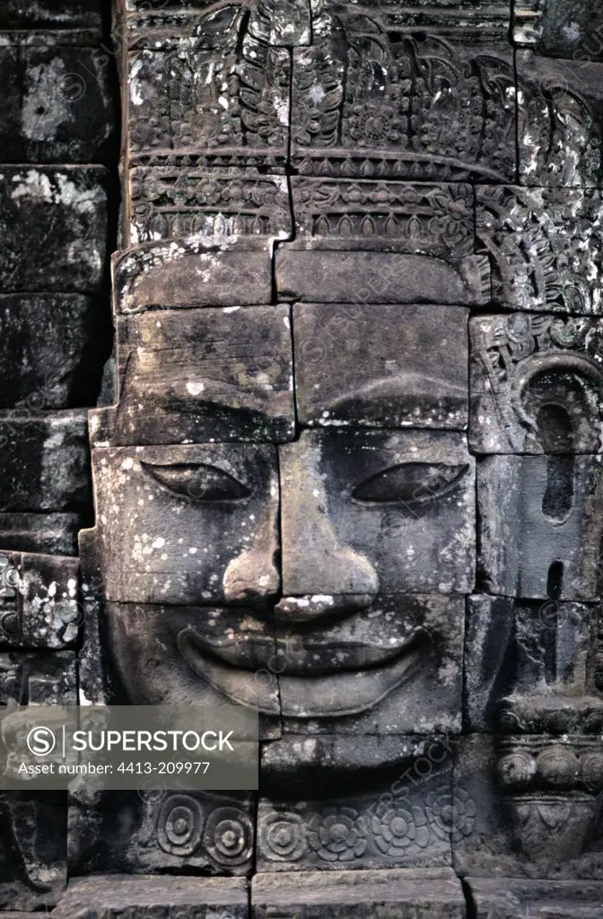 Face carved in the stone of a temple Siem Reap Cambodia