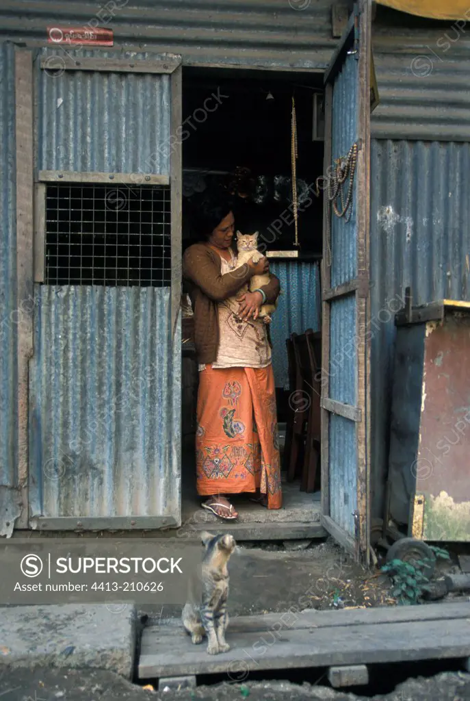 Woman wearing a cat at the entrance to a habitat Burma