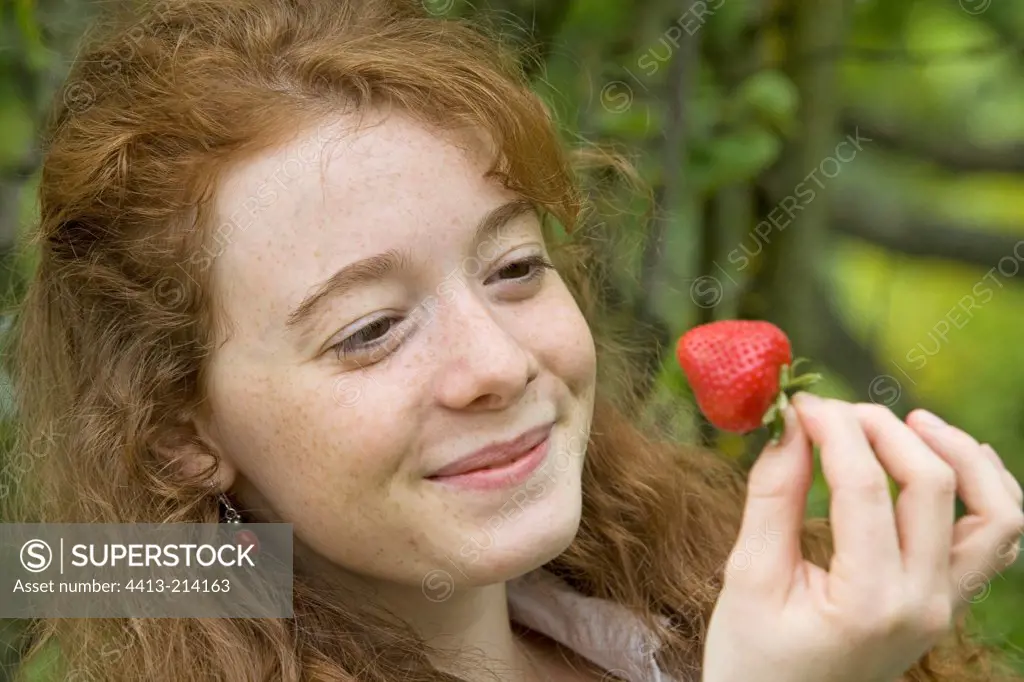 Portrait of a young girl about to eat a strawberry Provence