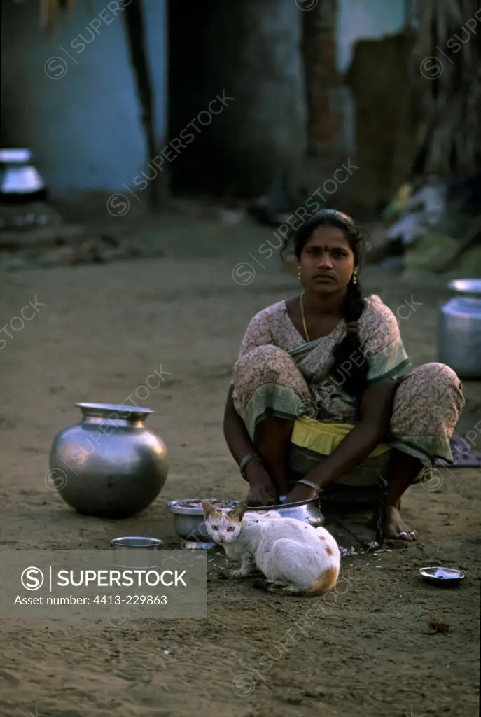 Cat and young woman sitting on the ground India