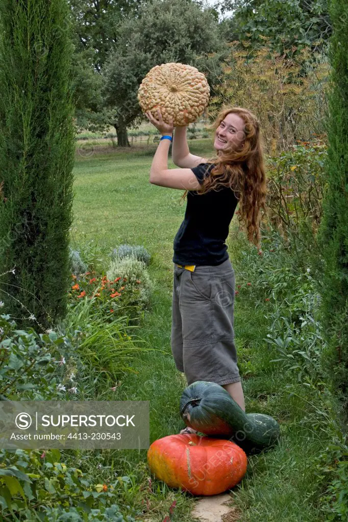 Young red-haired girl harvesting a squash 'Galeuse d'Eysine'