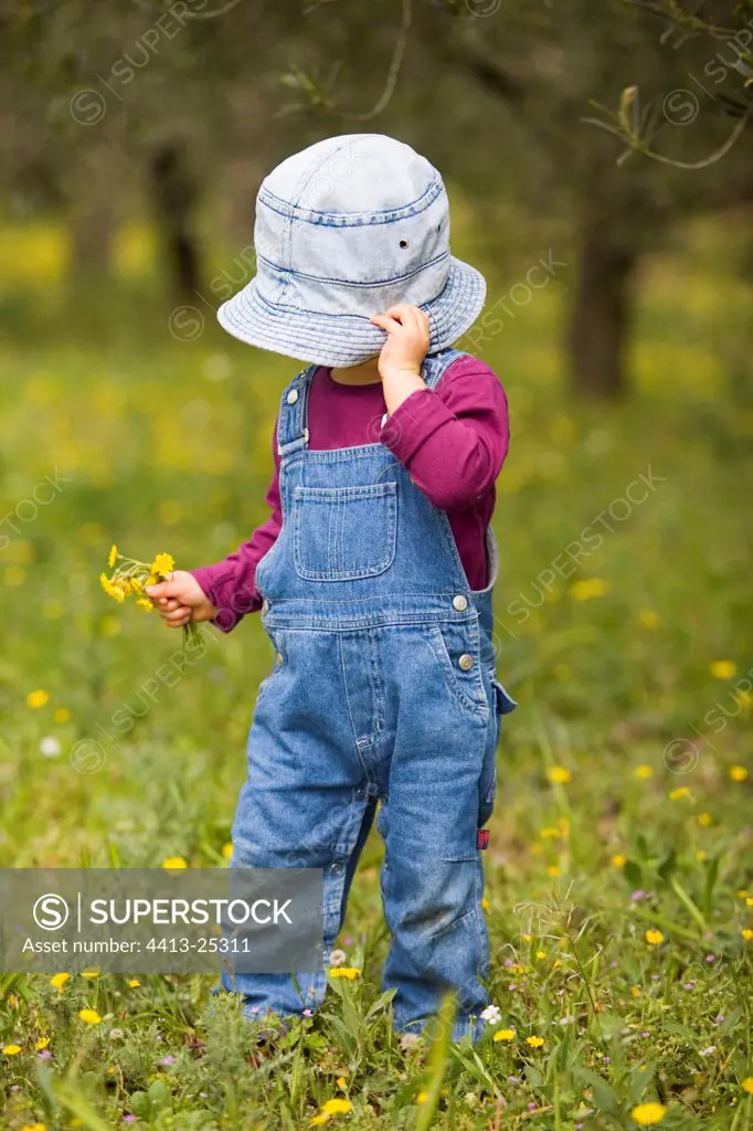 20 month old girl gathering of flowers in a garden France