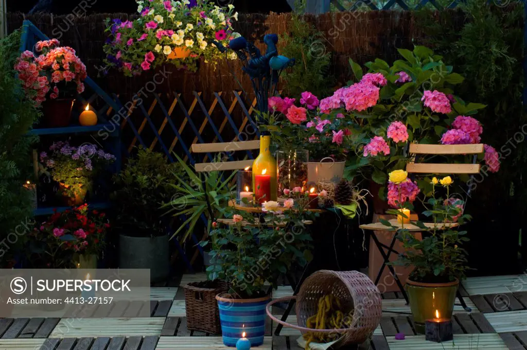 Flowered garden terrace lighted by candles