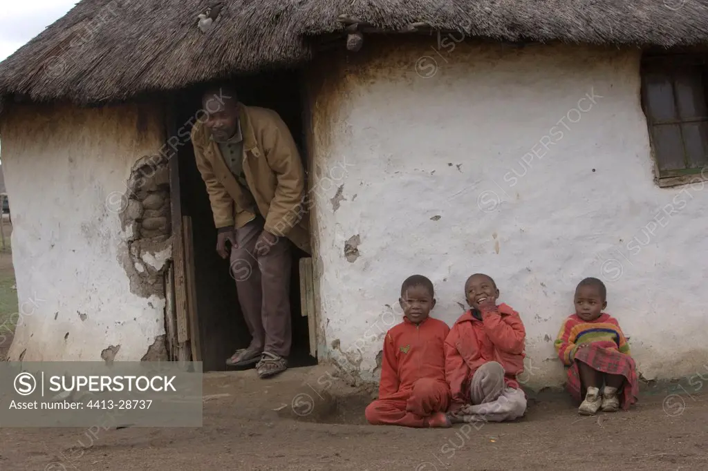 Zulu man and children in front of their hut South Africa