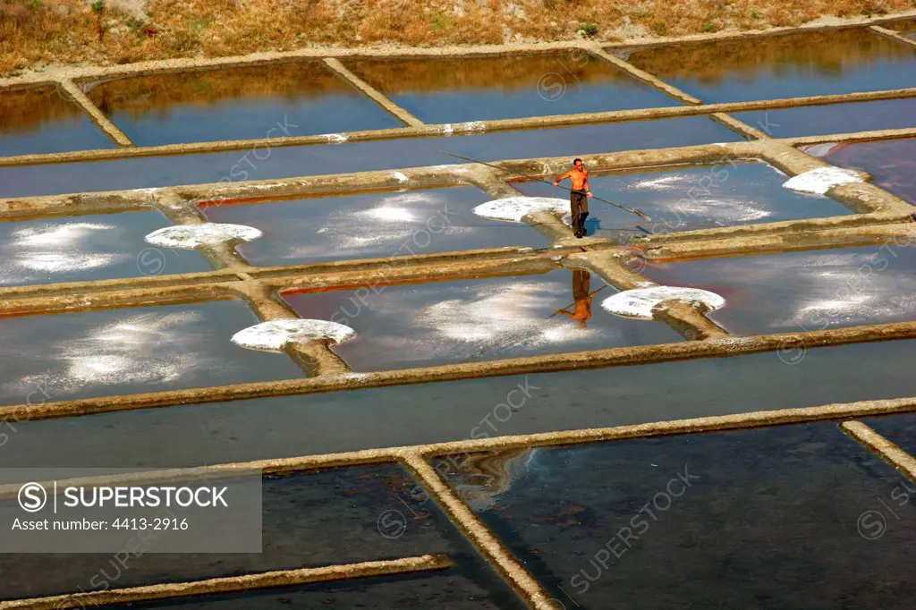 Man working in the salt-water marshes France