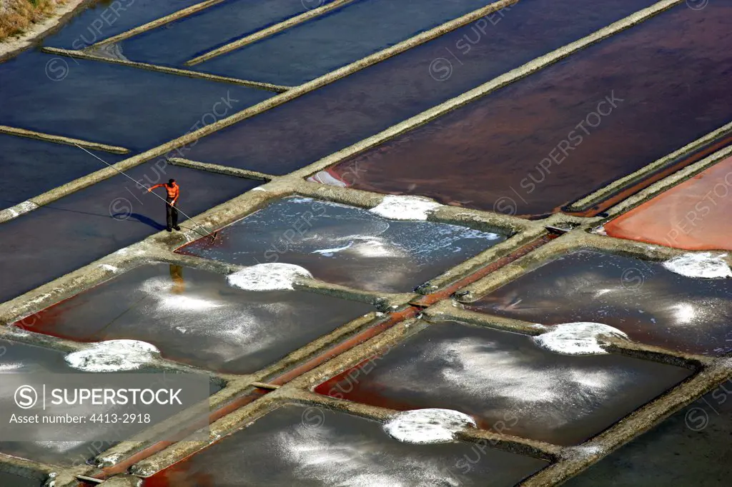 Man working in the salt-water marshes France