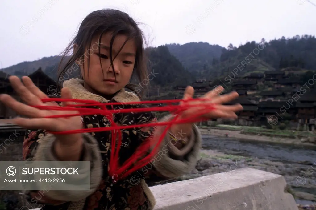 Girl of Dong ethnic group playing Province of Guizhou China