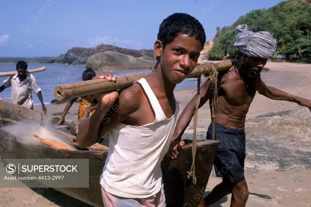 Young fisherman bringing back his boat Karwar India