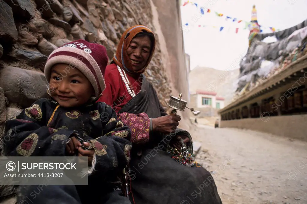 Tibetan child and his grandmother in front of a temple