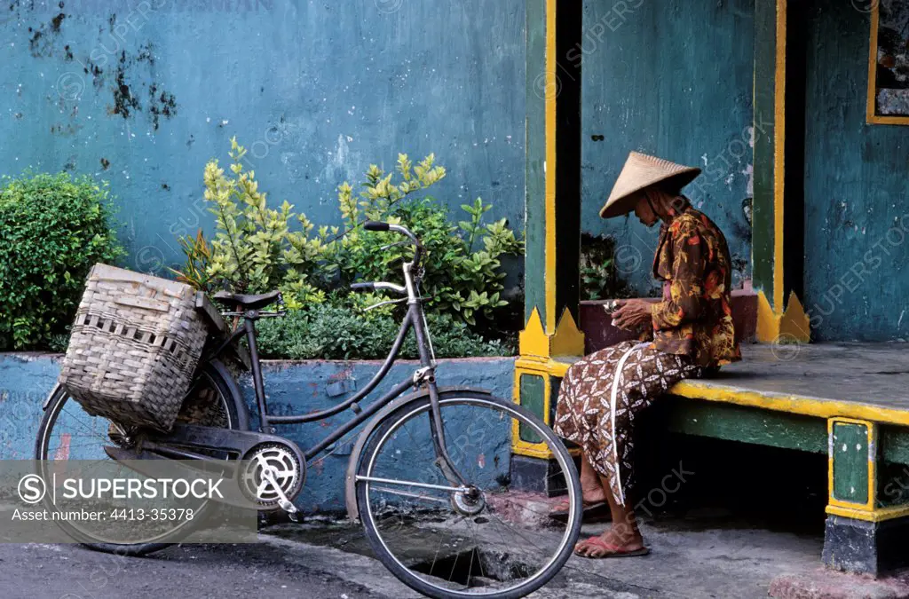 Woman sitting near her bicycle Yogyakarta Indonesia