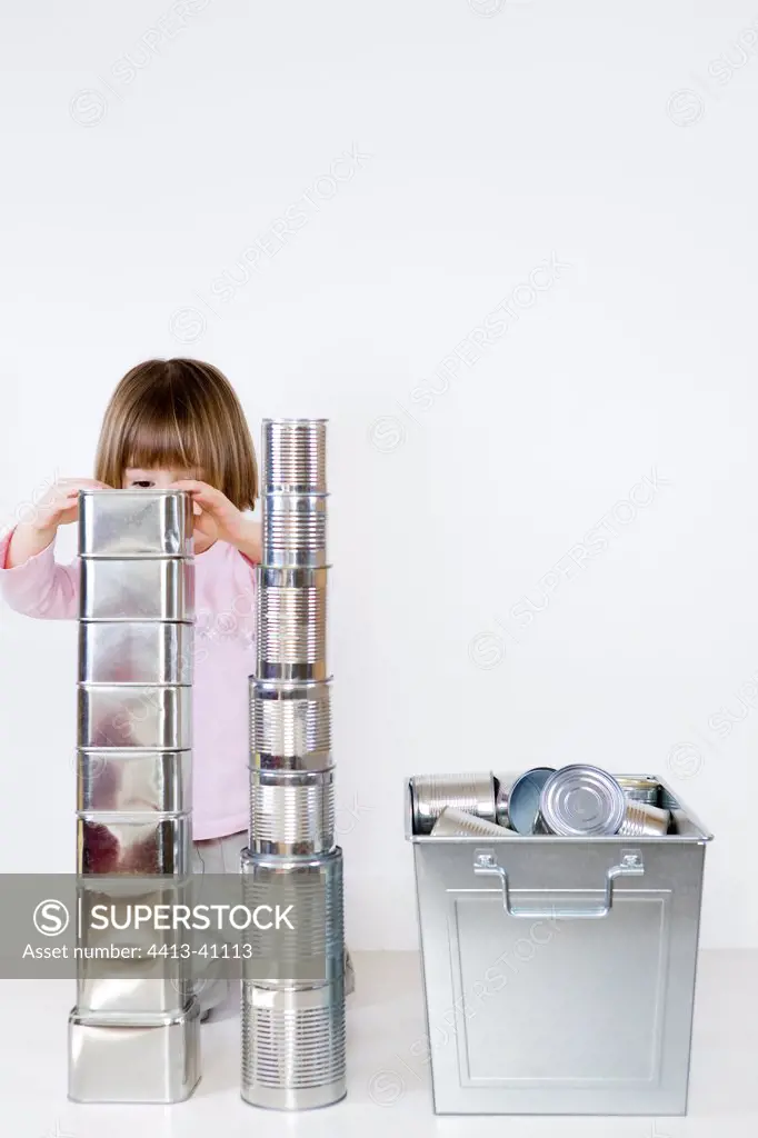 Girl playing to build a cans stack