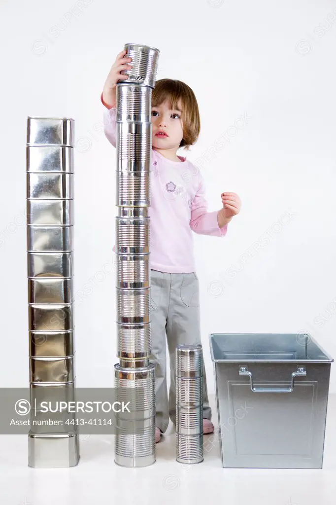 Girl playing to build a cans stack