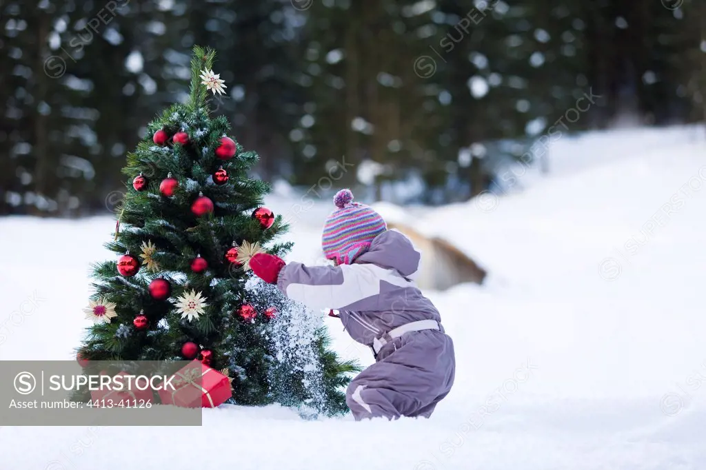 Girl discovering gifts at the foot of a Christmas Tree Alps