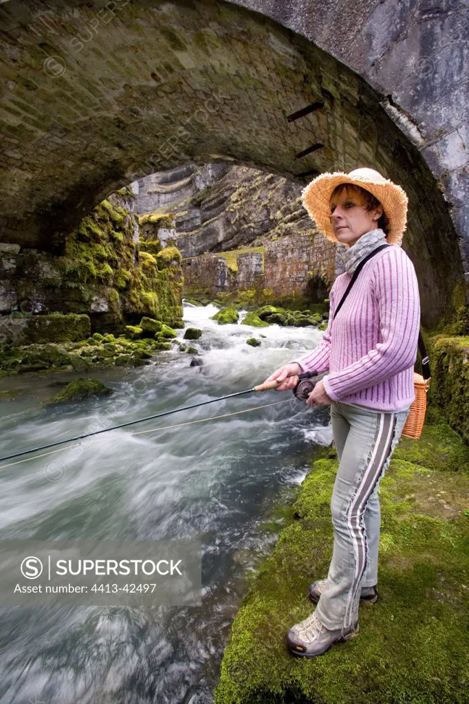 Woman fishing fly in the source of the Loue