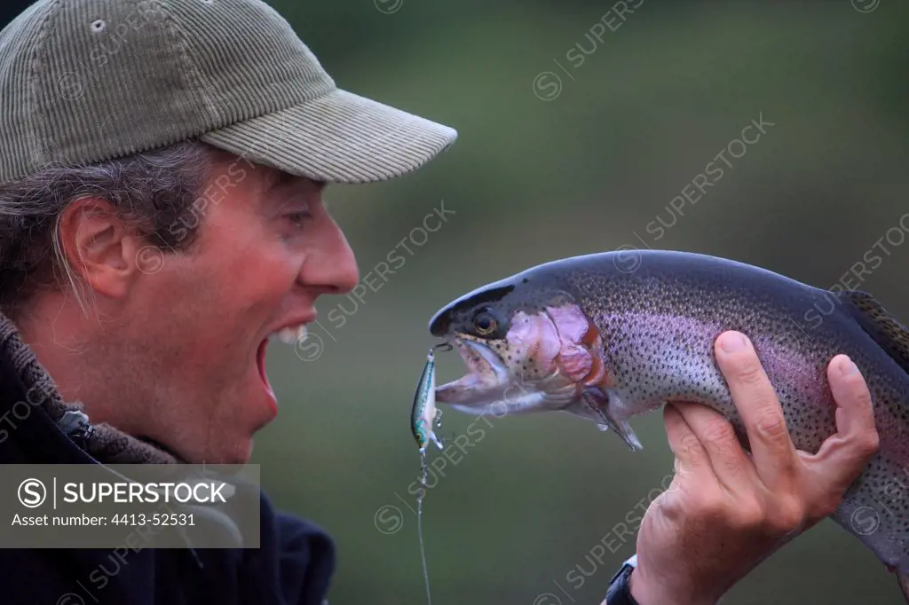 Happy fisherman in front of the trout he just catching Franc