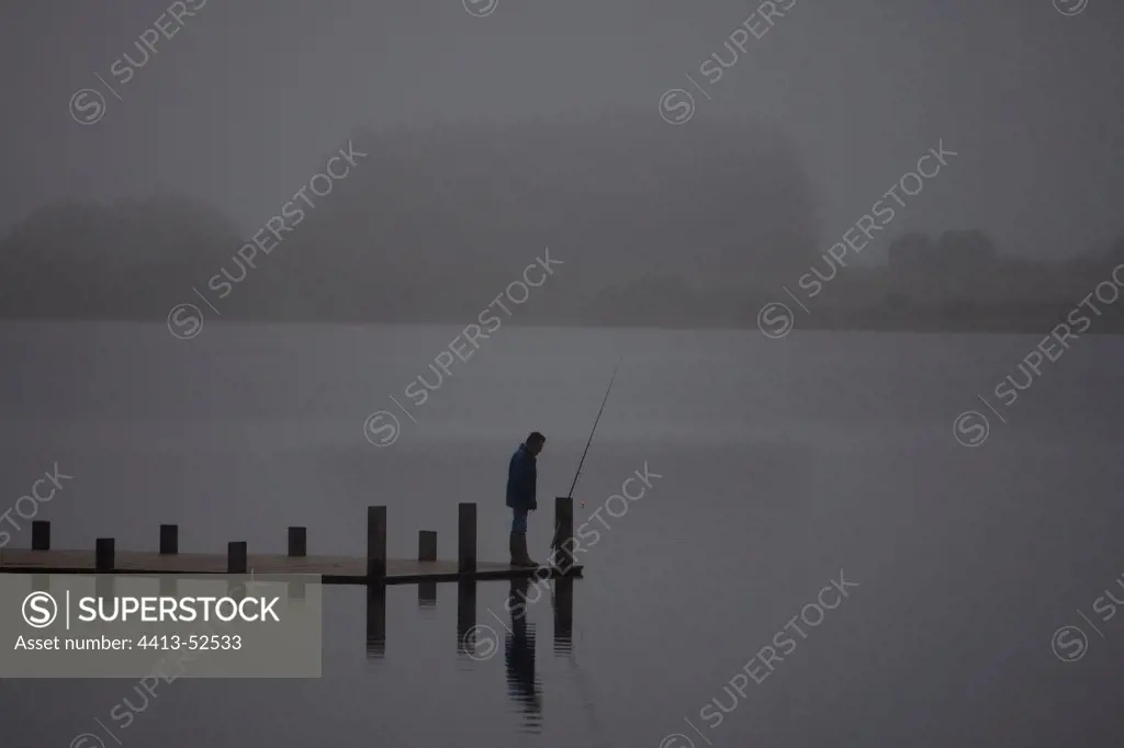 Fisherman on a pontoon of the Brennilis Lake