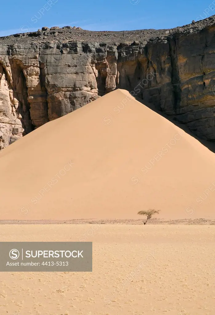Dune in formation against a rock mass Sahara Algeria
