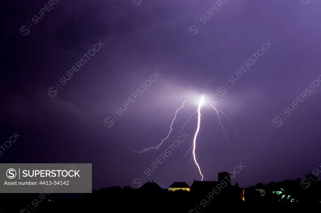 Staccato lightning strike behind a village France