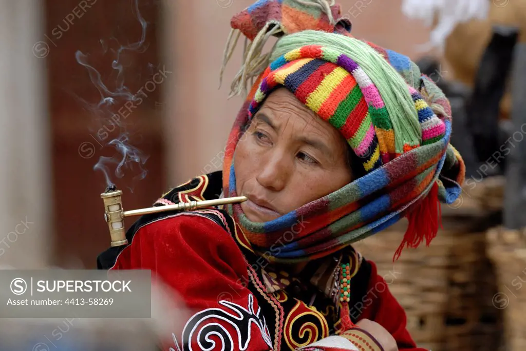 Moso woman smocking pipe in a village near Lake Lugu