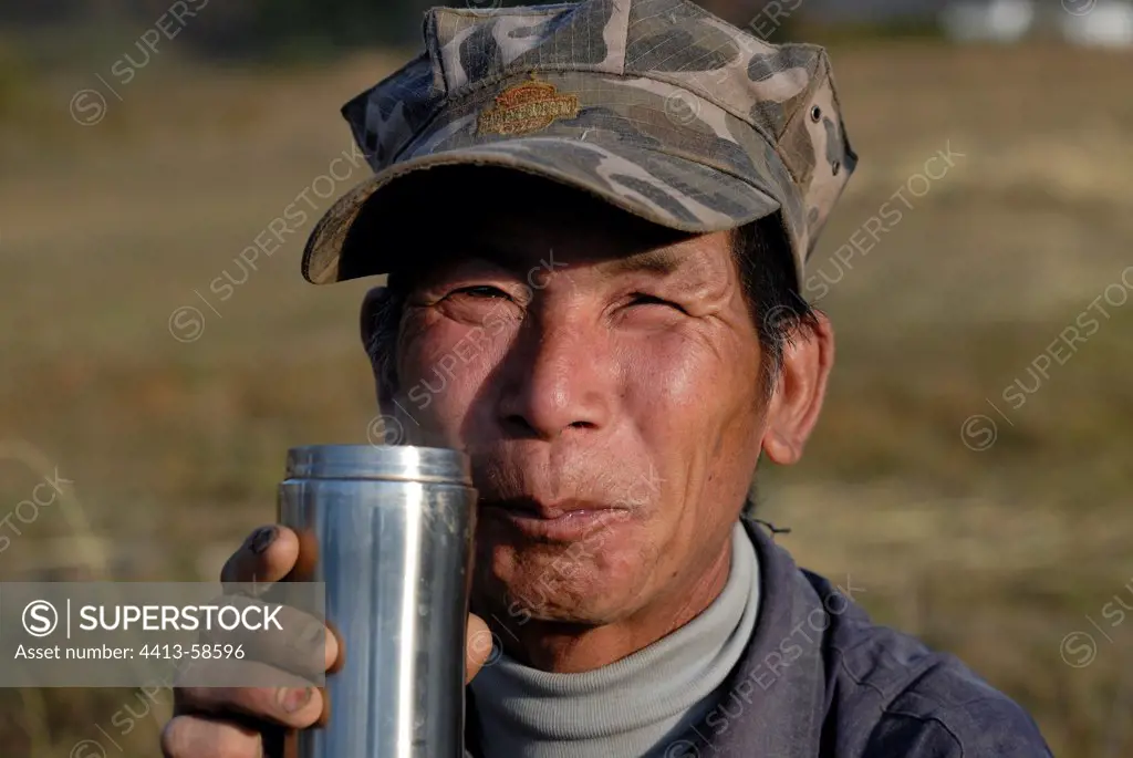 Moso peasant drinking tea after harvesting rice Yunnan