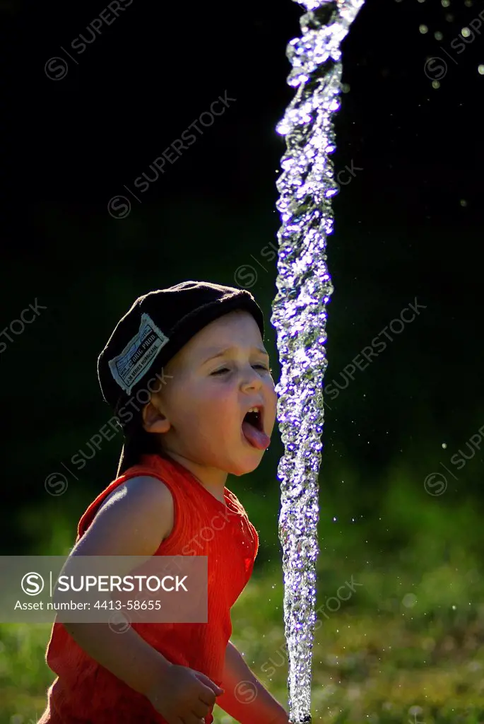 Children playing with a garden hose in summer France