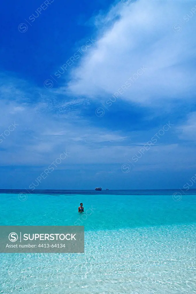 Swimmer in the blue waters of a lagoon in the Maldives