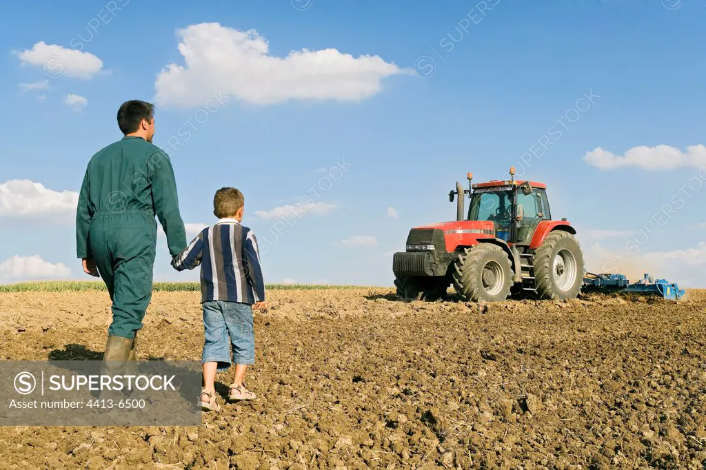 Farmer with his son in a plowed field France