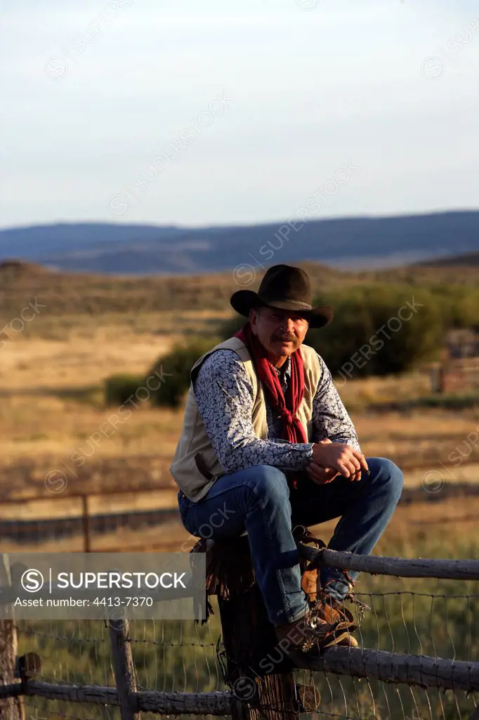 Cow-boy sitting on the barrier of the enclosure Oregon the USA